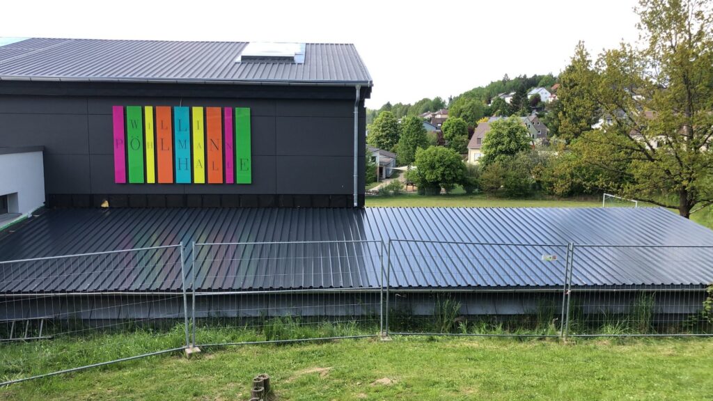 Halle mit dunklem Profilblechdach und dunkler Metallfassade