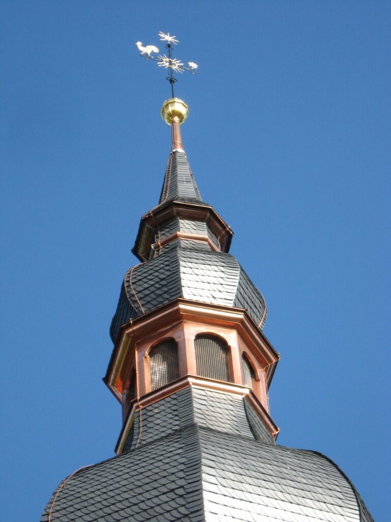 Kirchturm mit Schieferdeckung und Kupferverkleidung, an der Spitze ein vergoldeter Wetterhahn
