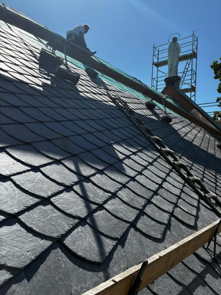 Neu gedecktes Schieferdach einer Kirche mit Dachleiter