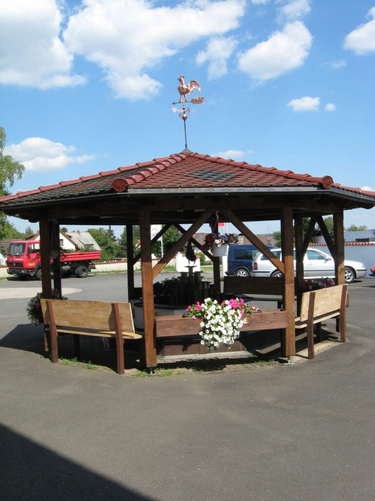 Achteckiger Holzpavillon mit Ziegeldach und Wetterhahn